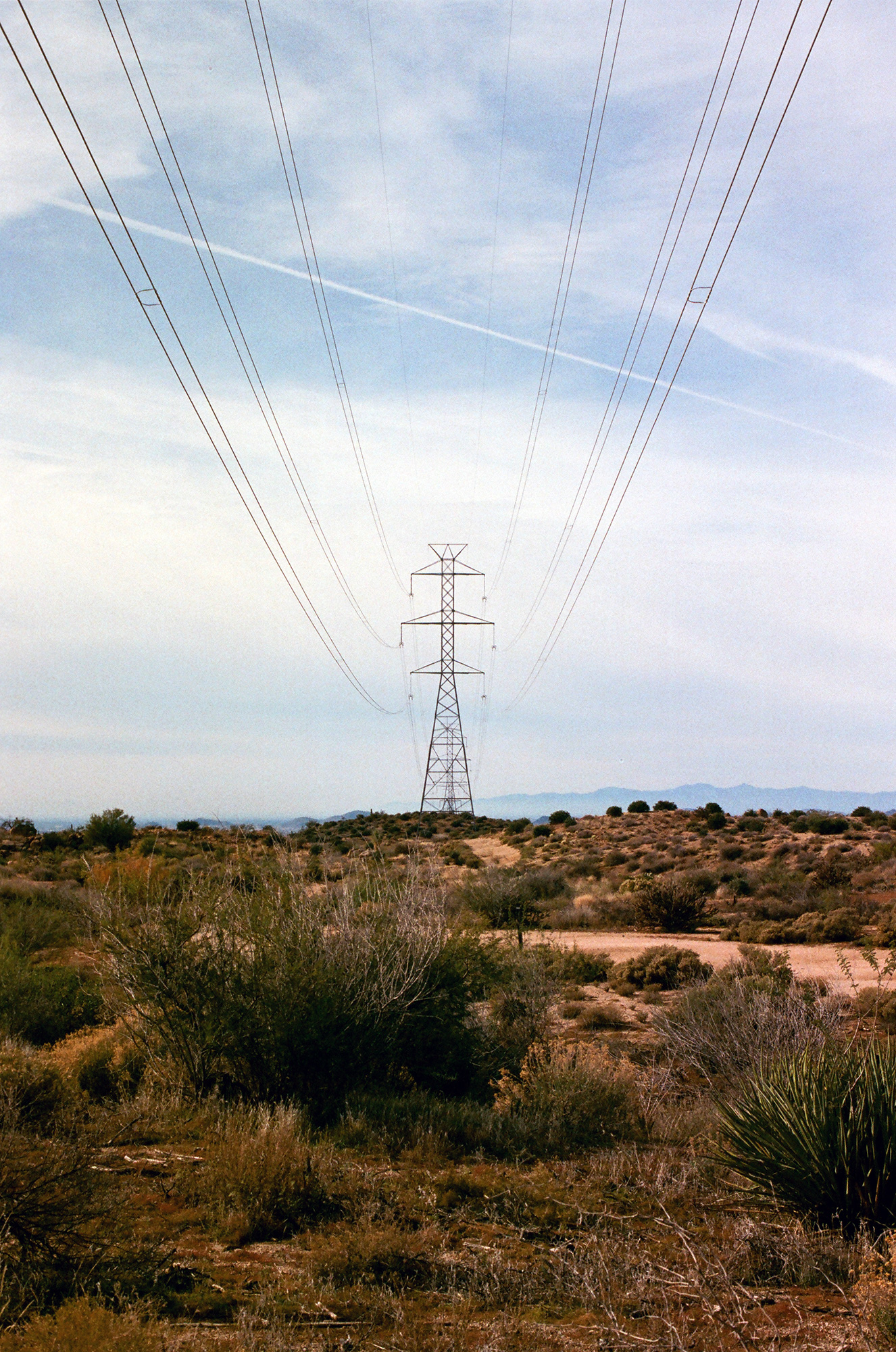 A lone power array cuts through the barren desert.